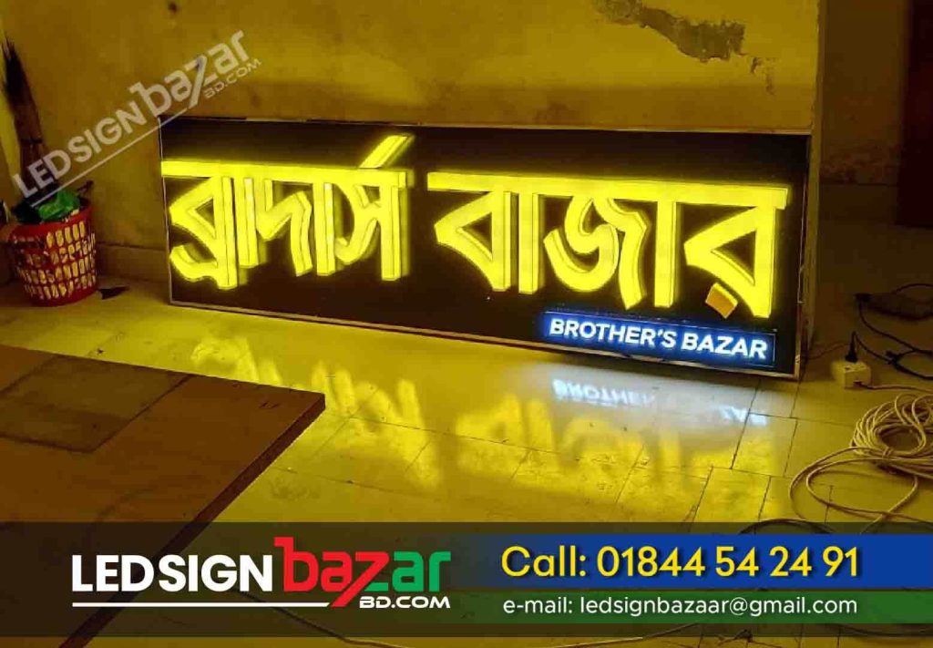 Project Name: Brothers and Bazar Shopping Mall front yellow LED letter sign board and billboard design and making service in Bangladesh.  Project Types: Acrylic Front Light Letter Sign Board. Back Site black-color acrylic sheet.  Sign Board Labor: We have 100+ Sign Board Fitting laborers, If you need any sign board labor, you can hire a laborer from LED Sign Bazar. Project Location: Bangla Bazar Bhola, Bhola Sadar, Barishal Rupatoli, Barishal BM College.  Project Materials: Plastic Sheet, LED Lighting Sign Board. Acrylic Sheet. 